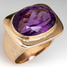 This vintage amethyst ring is centered with one (1) oval mixed cut natural amethyst set into a bright polished bezel setting. The tapered shank has a brushed finish. The ring measures 18.0mm at the top, rises 10.9mm above the finger, tapering to 4.7mm wide and 1.0mm thick at the base of the shank. It is currently a size 7.25. Luxury Amethyst Ring In Yellow Gold, Oval Amethyst Ring With Bezel Setting For Formal Occasions, Timeless Oval Purple Amethyst Ring, Timeless Purple Oval Amethyst Ring, Modern Oval Amethyst Ring With Polished Finish, Formal Amethyst Ring With Bezel Setting, Formal Purple Amethyst Ring With Bezel Setting, Vintage Amethyst Ring, Amethyst Ring Vintage