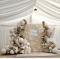 an elaborately decorated backdrop with balloons and balls for a wedding or special event in white