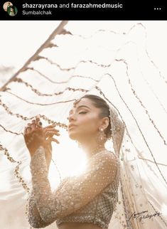 a woman in a wedding dress with pearls on her head and veil over her face