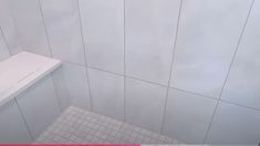 a white tiled shower stall in a bathroom