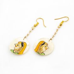 Introducing our exquisite collection of Hand Painted Mother of Pearl Earrings, a true reflection of Indian tradition and craftsmanship. These earrings feature real hand-painted artwork on mother of pearl, showcasing the rich cultural heritage and intricate work of its origin. The delicate hand-painted lady depicted on the mother of pearl exudes the essence of Indian culture and craftsmanship, adding a touch of elegance and charm to the earrings. Each piece is meticulously crafted with attention Traditional Wedding Earrings With Artistic Design, Traditional Jewelry With Motifs For Navratri, Ceremonial Temple Jewelry With Motifs, Elegant White Jewelry With Artistic Design, Navratri Themed Motif Jewelry Gift, Kundan Jewelry With Motifs For Navratri, Elegant Ceremonial Earrings With Motifs, Intricate Kundan Jewelry Sets, Meenakari Jewelry Gift