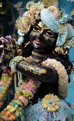 an elaborately decorated statue is shown in front of a blue wall