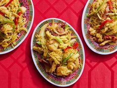 three plates filled with food on top of a red table