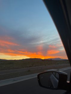 the sun is setting in the distance as seen from inside a car