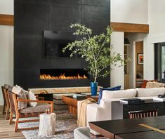 a living room filled with furniture and a fire place in the middle of the room