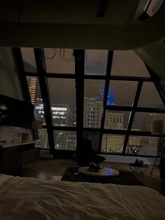 a bedroom with a view of the city at night