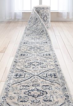 a white and blue runner rug in front of a window