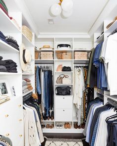 an organized closet with clothes, shoes and other items on shelves in white painted walls