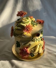 a three tiered cake decorated with flowers and leaves