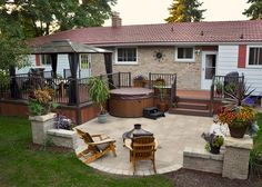 a backyard with a hot tub and patio furniture