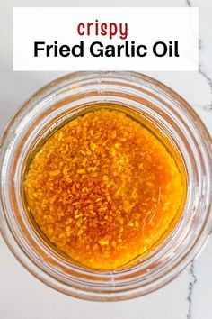 a glass jar filled with yellow liquid on top of a white counter next to a marble surface