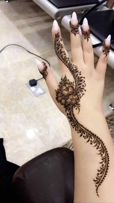 a woman's hand with henna tattoos on it