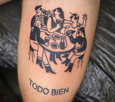 a tattoo on the leg of a man with three people sitting at a table