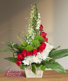 a vase filled with red and white flowers