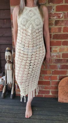 Hand crochet from 100% cream cotton / slight lemon tint . Size 8 but will fit a small 10. Model in photo is size  8-10 . Dress is calf length with Fringing. Small button on back to do up. Scooped at front so slightly shorter at back.  Can be worn with a slip,  wear over swimwear or be brave and show off you summer body over your favourite knickers. Dress is handmade . White Crochet Lace Maxi Dress For Beach, White Bohemian Crochet Maxi Dress, Beige Crochet Maxi Dress For Beach, Summer Beige Long Crochet Dress, Beige Long Crochet Dress For Summer, Cream Crochet Dress For Summer Beach, Cream Crochet Dress For Beach In Summer, Cream Maxi Dress For Beach, Cream Sleeveless Crochet Dress For The Beach