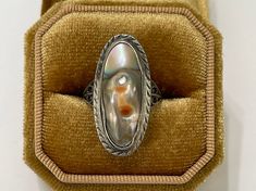 "Beautiful large statement-size vintage sterling silver blister pearl ring. The 1930s era ring features an oval shaped blister pearl with orange, purple, green and gray colors. The pearl is bezel set & has such a lovely luster, colors, and rise. The setting is beautifully detailed. Stunning piece of late Art Deco jewelry! ERA - Circa 1930s, Art Deco METAL / MATERIAL - Sterling silver metal, blister pearl MARKINGS / HISTORY - Stamped \"Sterling\" on back of ring head. CONDITION - Good antique condition. Blister pearl is in good condition with only very light age appropriate wear, and is secure in setting. Some light tarnish. Stunning and unique antique ring! SIZE / MEASUREMENTS - Size: 8.5, Stone: About 25 x 9.8 mm, Weight: 3.02 grams" Victorian Oval Pearl Ring With Gemstone, Art Deco Oval Cabochon Collectible Jewelry, Estate Oval Jewelry For Gifts, Heirloom High Luster Oval Pearl Ring, Victorian Oval Cabochon Pearl Ring, High Luster Vintage Ring Jewelry, Oval Heirloom Pearl Ring, Vintage High Luster Rings For Anniversary, Heirloom Silver Oval Pearl Ring