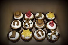 twelve cupcakes decorated with cowboy hats, stars and symbols are arranged in the shape of letters