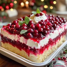 a piece of cake with cranberry sauce and whipped cream on top is sitting on a plate