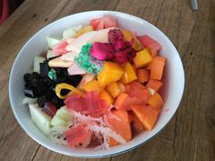 a white bowl filled with lots of cut up fruit