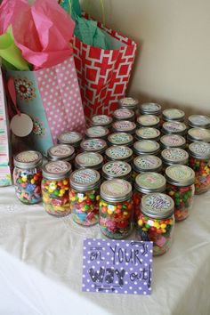 a table topped with lots of jars filled with candy