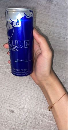 a person holding up a can of blue lion energy drink