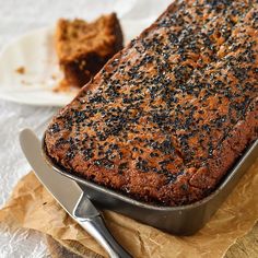 a loaf of cake sitting on top of a table next to a knife and fork