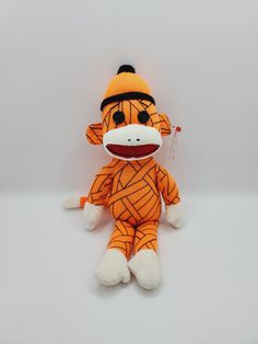 a stuffed animal monkey wearing an orange outfit