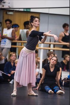 a woman in a pink skirt is doing ballet