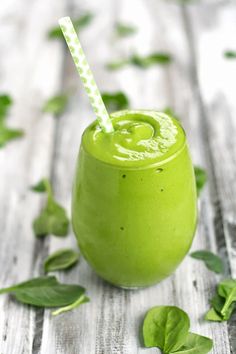 a green smoothie with a straw in it