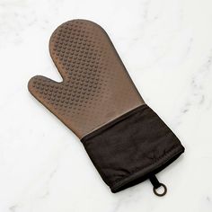 an oven mitt on a marble countertop with a black cloth around the mitt