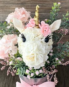 a unicorn head made out of flowers with a pink bow on the front and side