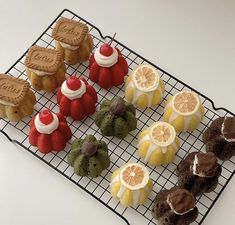 there are many different types of pastries on the cooling rack, including oranges and lemons