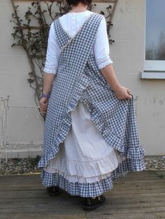 a woman in a dress standing on a porch