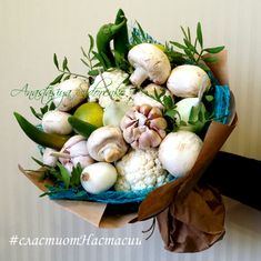 a bouquet of flowers and vegetables is wrapped in brown paper