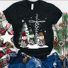 a black t - shirt with three snowmen riding bikes in the snow on it