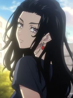 a woman with long black hair and piercings on her ear looking off to the side