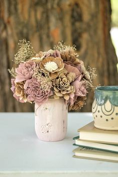 a vase filled with flowers sitting on top of a table next to a stack of books