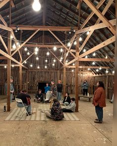 people are sitting and standing in a barn