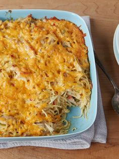 a casserole dish with cheese and meat in it on a blue plate next to a fork