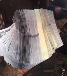 a stack of money sitting on top of a person's arm