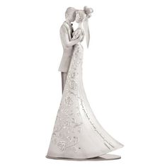 a white wedding cake topper with a bride and groom holding each other in their arms