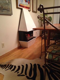 a living room with a fire place in the corner and zebra rug on the floor