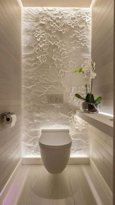 a white toilet sitting inside of a bathroom next to a window with flowers in it