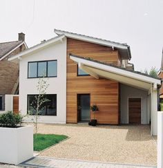 a modern house with wood siding and white trim on the front door is seen in this image