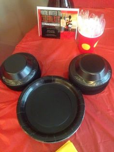 three black plates sitting on top of a red table cloth