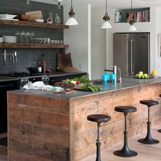 a kitchen with an island and several stools in front of the countertop area