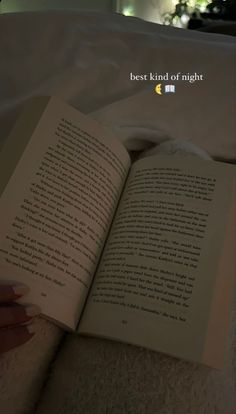 an open book sitting on top of a bed