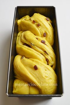 a metal container filled with yellow frosting on top of a table