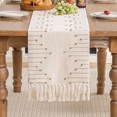 the table is set with bread, grapes and other food items on top of it