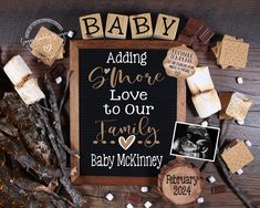 a baby announcement with marshmallows, cookies and candies on a wooden table